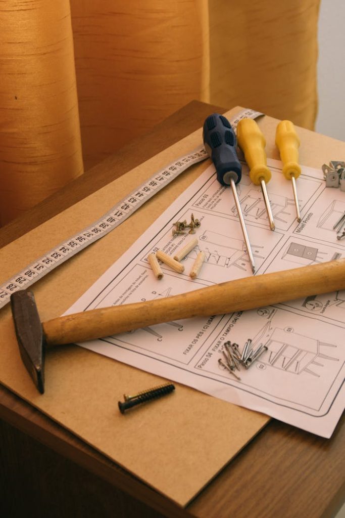 A set of tools and instructions for assembling DIY furniture, including a hammer and screwdrivers.
